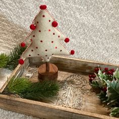 a small christmas tree sitting on top of a wooden tray