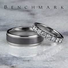 two wedding rings sitting on top of a marble surface with the words bench mark written above them