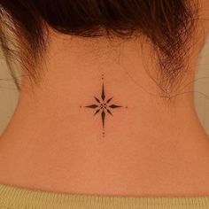 a woman's neck with a small star tattoo on the back of her neck