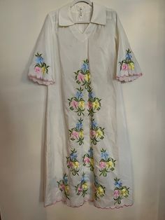 "Vintage 70s handmade Chriffronelle embroidered fabric kaftan. Sheer maxi kaftan with floral embroidery in amazing vintage condition. Beautiful detailing along hem and sleeves with pink embroidered, scalloped border. Floral embroidery in pink, yellow, blue, and green. Dress features 3/4 length bell sleeves, v-neck, collar in front and back with zip and hook and eye closure. Material listed as chiffronelle polyester and pima cotton. Size not listed, as dress is handmade, but would fit up to a siz Spring Maxi Dress With Resham Embroidery, Spring Cotton Kaftan With Floral Embroidery, Spring Multicolor Embroidered Floral Kurta, Spring Floral Print Kurta With Multicolor Embroidery, Floral Embroidery V-neck Kurta For Spring, Spring V-neck Kurta With Floral Embroidery, V-neck Kurta With Floral Embroidery For Spring, Spring Folk Style Embroidered Kaftan, Embroidered Folk Style Kaftan For Spring