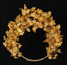 a gold wreath with leaves and flowers on it