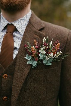 a man wearing a suit and tie with flowers in his lapel flower pinion