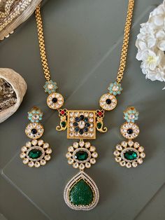 Elevate your style with our premium pendant necklace set. Crafted to perfection, this set exudes timeless beauty and unmatched quality, ensuring you stand out on every occasion. Product Details: Material: Crafted from high-quality brass, copper, dual tone plating, stones, beads, enamelled work, Kundan embellishments, this necklace boasts enduring quality and a radiant finish. Necklace Dimensions: Weight: 70 grams Drop Length: 11 inches. Closure Type: Hook Adjustable Size: Yes Pendant Dimensions: Height: 4.5 inches Width: 2.5 inches Earring Details: Weight (Per Pair): 32 grams. Length: 6.5 cm Width: 3.5 cm Closure Type: Push Back Closure with Extra support clip at the back. Unparalleled Craftsmanship: Our artisans have poured their skill and passion into creating a set that will leave admir Amrapali Necklace, Brass Pendant Necklace, Wedding Jewelry Sets, Brass Pendant, Timeless Beauty, Necklace Set, Jewelry Sets, Timeless Design, Wedding Jewelry