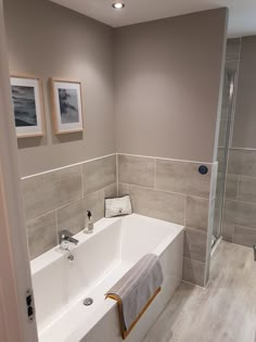 a white bath tub sitting inside of a bathroom next to a walk - in shower