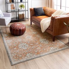 a living room with a couch, chair and rug on the floor in front of a window