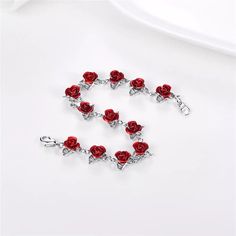 a red rose charm bracelet with matching clasps and lobster claw clasps, on a white background