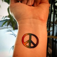 a small peace sign tattoo on the wrist