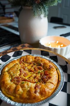 a pizza sitting on top of a metal pan next to a vase filled with flowers