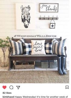 a wooden bench sitting in front of a wall with two framed pictures on the wall