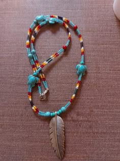 a beaded necklace with a feather charm