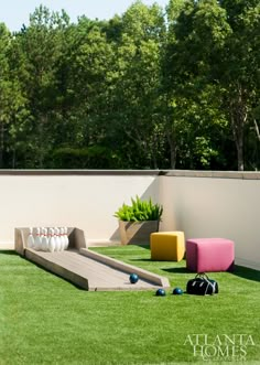 an artificial lawn with bowling balls and a slide