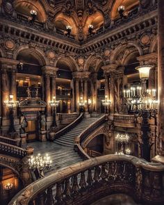 an ornate staircase with chandeliers and lights in a large building that looks like a palace