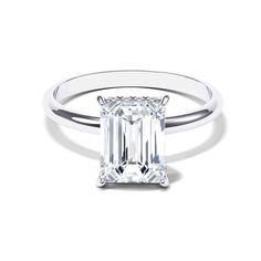 an emerald - cut diamond ring with a thin band on the side, set in 18k white gold