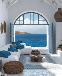 a living room filled with furniture and an open window to the ocean in front of it