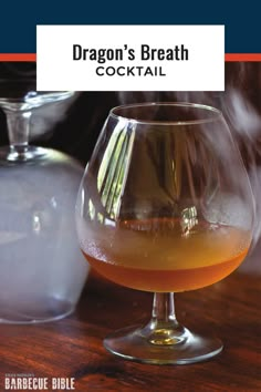 a glass filled with liquid sitting on top of a wooden table