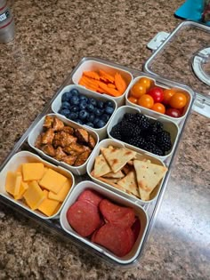 a tray filled with different types of food on top of a counter next to a bottle of water