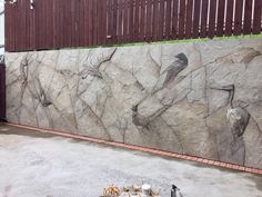 a large rock wall in front of a fence