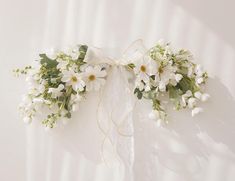 a bouquet of white flowers tied to a wall