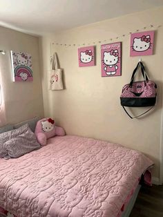 a hello kitty bedroom with pink bedding and pictures on the wall above the bed