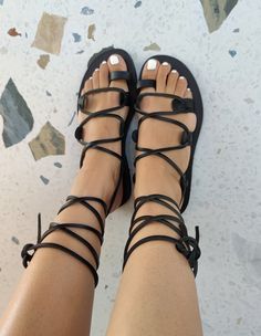 Greek Black Leather Sandals are made from 100% genuine Cretan leather in Greece. ❤ Description - 100% Greek Leather - 100% Handmade Sandals - The sole is lightweight and handmade with high-durable rubber. - Every pair of our leather sandals is unique. Small natural marks or light color irregularities are common in these types o shoes. These are absolutely physical, as no chemicals are used. People who wear handmade jewelry or accessories love that small imperfections.  - The sandals are available in two colors: black and gold ❤ RETURN & EXCHANGE POLICIES - Buyer is responsible for return shipping costs # IN CASE OF RETURN OR EXCHANGE, YOU WILL BE CHARGED THE ABOVE PRICES: If the sandals were purchased with free standard shipping, I will issue a refund of 80% of the cost. If the sandals wer Summer Flat Shoes, Vacation Sandals, Tie Up Sandals, Handmade Sandals, Black Leather Flats, Summer Flats, Black Leather Sandals, Greek Sandals, Lace Up Sandals