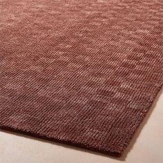 a close up view of the textured fabric on an area rug in brown and pink