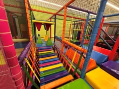 an indoor play area with colorful slides and obstacles