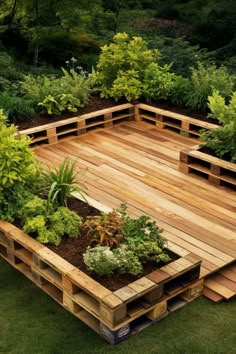 a wooden deck surrounded by lots of plants and trees in the middle of a yard