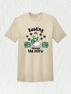 Imagine yourself at the library during the holiday season, surrounded by shelves lined with books. As you make your way through the stacks, you stumble upon a t-shirt that perfectly captures the magic of Christmas and the love for reading. Our Christmas Reading Through The Snow Shirt is the perfect gift for teachers and bookworms alike. Get ready to show off your love for books with this delightful and festive tee.Christmas Reading Through The Snow Shirt, Christmas Library T-Shirt, Bookworm Christmas Tee, Gift For Teachers Sand Casual  Short Sleeve  Animal,Cartoon,Christmas,Colorblock,Figure,Geometric,Graphic,Letter,Striped,Plants,Slogan,Textured Pattern    Women Clothing, size features are:Bust: ,Length: ,Sleeve Length: Library Christmas Shirt, Library Christmas Shirts, Christmas Library, Stand Collar Top, Christmas Reading, Cute Letters, Cartoon Christmas, Geometric Graphic, Animal Cartoon