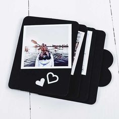 three black coasters with photos and hearts on them sitting on a white table top