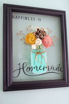 a frame with flowers in it that says happiness is homemade