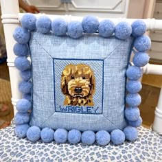 a blue pillow with a dog on it and some balls around the edges, sitting on a chair