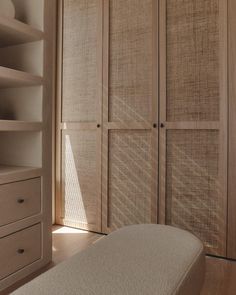 an empty bedroom with wooden closets and drawers