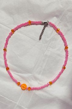 Smiley emoji beaded necklace, Indie seed beaded choker, 90s pink aesthetic necklace, Kidcore happy face necklace, Positive energy jewelry ☙ The cutest smiley faces are here to steal your heart and help you achieve this back in the 90s nostalgia style. It is lightweight and comfortable to wear everyday with your casual outfits to add a playful touch. You can wear a single one for a more minimalist style, or add more beaded chokers from my collection for a layered result. Pick between two color options, pink with orange smiley face or yellow with purple smiley face. You can also offer it to your friends as a birthday gift or their school year start gift etc. ❧ Details : ❥ Smiley face size : 1 cm ❥ The necklace has extended chain to fit up to 5 cm ≈ 2 inches length Materials : ❥ The smiley fa Trendy Pink Choker With Round Beads, Adjustable Y2k Style Jewelry With Round Beads, Trendy Pink Beaded Choker, Trendy Pink Tiny Beads Choker, Trendy Pink Choker With Tiny Beads, Y2k Style Adjustable Colorful Beaded Jewelry, 90s Pink Aesthetic, Adjustable Beaded Y2k Jewelry, Adjustable Y2k Style Necklaces