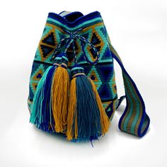 This unique summer bag, crafted in a boho chic style, was meticulously handwoven by the indigenous Wayuu community of Colombia. Designed to endure the test of time, it carries with it the promise of good fortune and cherished memories for a lifetime.This is an unlined drawstring crochet bag Size: 11"H x 9"W, circle bottom Strap has a 21" drop but is soft enough to be knotted and worn as a short shoulder or handle. Blue Woven Crochet Bucket Bag, Blue Crocheted Woven Bucket Bag, Handwoven Pouch Bucket Bag For Travel, Bohemian Multicolor Bucket Bag For Travel, Blue Handwoven Bag As A Gift, Handmade Bucket Bag For Festivals, Blue Handwoven Bucket Bag, Blue Crochet Travel Pouch Bag, Blue Handwoven Bucket Bag For Everyday