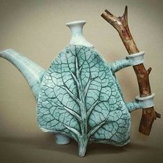 a teapot shaped like a tree with leaves on it