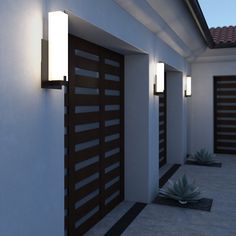 an exterior view of a house with two lights on the wall and one light on the door