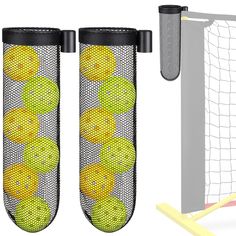 two yellow balls are in the net next to a soccer goal and ball tees