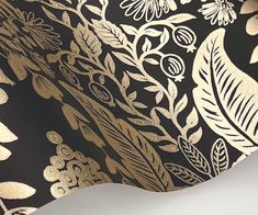 a black and gold wallpaper with white flowers, leaves and vines on it's side