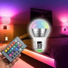 a person is holding a remote control in front of a bed with lights on it