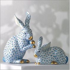 two blue and white ceramic rabbits sitting next to each other