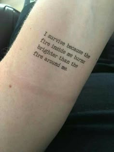 a person with a tattoo saying i survived because the fire inside me burns brighter than the fire around me