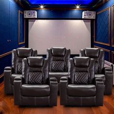 three recliner chairs in front of a projector screen with speakers on each side