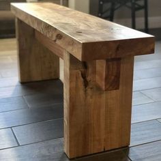 a wooden bench sitting on top of a tile floor