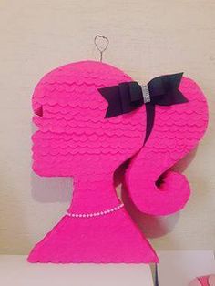 a pink paper cut out of a woman's head with a bow on it