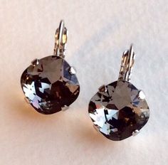 Made with the Finest Austrian Crystals. Feminine Earrings Handmade With the Finest 12mm Cushion Cut Crystals, handset in a Rhodium setting. Other settings are available. The color of these Earrings is Black Diamond a perfect Gray. Perfect Color! Great Bridesmaid Gift! Beautiful ! Designed and handcrafted by me. Thanks for taking a look. To see all the other Crystal Color Choices for this Gorgeous Earring, please see this listing: https://www.etsy.com/listing/914986061/the-finest-crystal-12mm-cus Cushion Cut Earrings, Stud Earrings Black, Feminine Earrings, Smoky Crystal, Bling Earrings, Back Drop, Swarovski Crystal Earrings, Earrings Black, Swarovski Jewelry