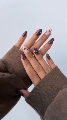 a woman's hands with black and white manicures on their nails, holding her hand up to the camera