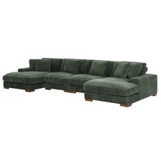 a green sectional couch with wooden legs and pillows on the bottom, in front of a white background