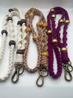 four different types of lanyards with metal clasps and wooden beads on them