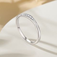 Simply and chic, this band is a clever accessory you will love. Featuring white stones, this band is an elegant symbol of your marital commitment. Buffed to a brilliant luster, this comfort-fit wedding band  will make your vows shine.Carat Weight: 0.086 ctStone Size: 1.1,1.3,1.5 mmStone Type: Jeulia® StoneNumber of Stones: 5 Stone Color: Diamond WhiteStone Shape: RoundWeight: 1.6 gWidth: 1.8 mmHeight: 1.8 mmThickness: 1.1 mmMaterial: 925 SilverPlating Color: Silver Elegant Adjustable Crystal Ring In Diamond White, Elegant Adjustable Diamond White Crystal Ring, Promise Stackable Rings With White Round Band, Elegant Adjustable Diamond Ring With Cubic Zirconia, Minimalist Adjustable Diamond Ring With Accents, Adjustable Minimalist Diamond Ring With Accents, Elegant Adjustable Cubic Zirconia Diamond Ring, Elegant Adjustable Crystal Ring For Anniversary, Elegant Stackable Diamond Ring