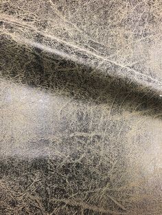 the surface of a concrete wall is covered in gray and white paint with streaks of light coming from behind it